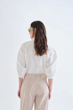 Load image into Gallery viewer, Compania Fantastica white cotton shirt with colourful decorative buttons.  The model  is shown from behind, the look is simple yet stylish and relaxed with collared shirt and elasticated cuffs.