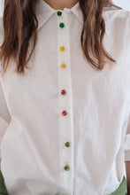 Load image into Gallery viewer, A close-up of a white button-down shirt worn by a person, featuring colorful translucent buttons in green, yellow, and red along the front placket.
