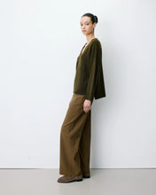 Load image into Gallery viewer, The Grace and Mila Salvador khaki jumper, crafted from a subtle lurex knit, it has the softest shimmer giving it a certain elegance. It has a relaxed fit, long sleeves, v-neckline and small side slits with ribbed finished cuffs.  Simple yet stylish, easy to wear and a classic for your wardrobe.
