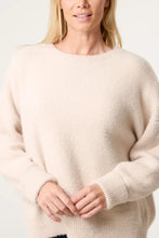 Load image into Gallery viewer, A woman wearing a soft, fuzzy crewneck sweater in a light cream or oatmeal color, shown from the chest up against a plain light background.